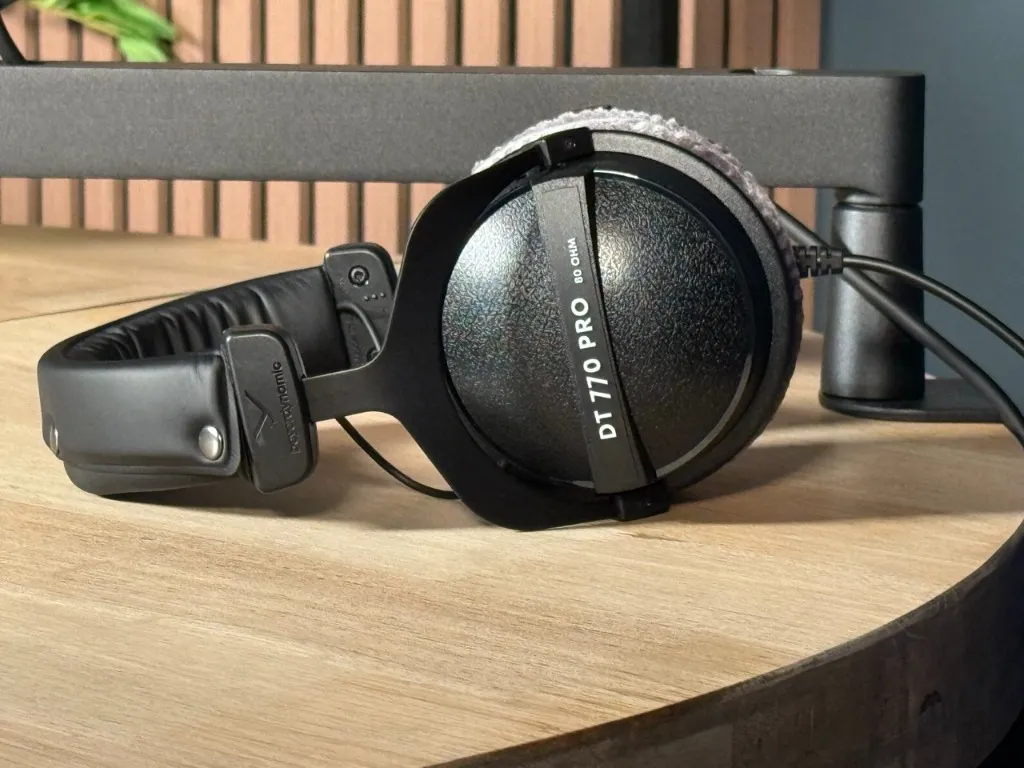 beyerdynamic DT 770 PRO studio headphones on the oak recording table in front of wooden acoustic panels